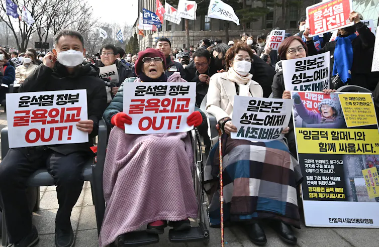 Senior citizens hold signs at a rally