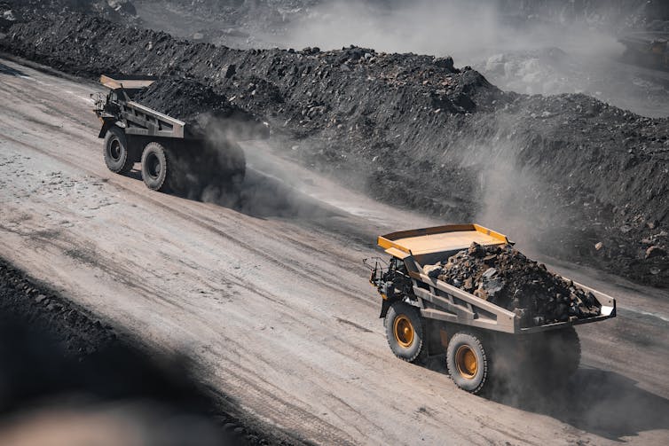Trucks carry loads of coal at a mine