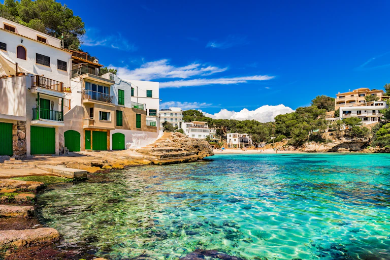 Vista de un pueblo junto al mar, con casas blancas y un agua casi transparente