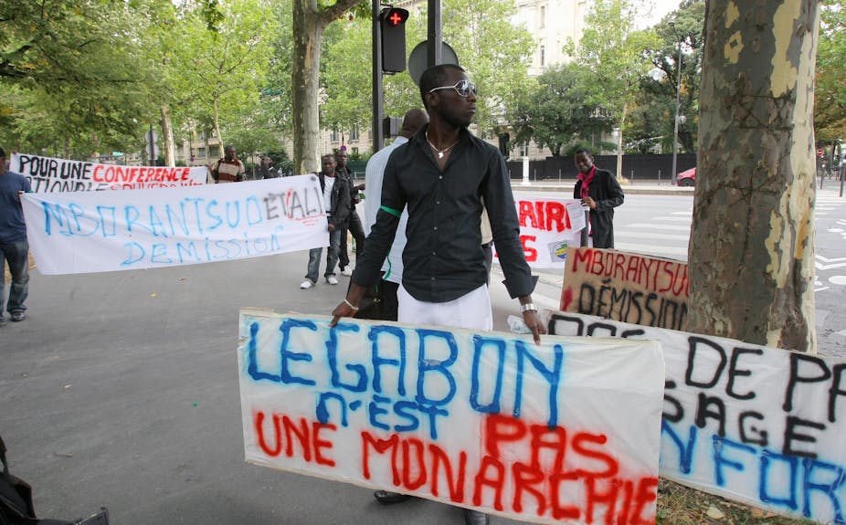 Un homme porte une pancarte avec la mention : Le Gabon n'est pas une monarchie"