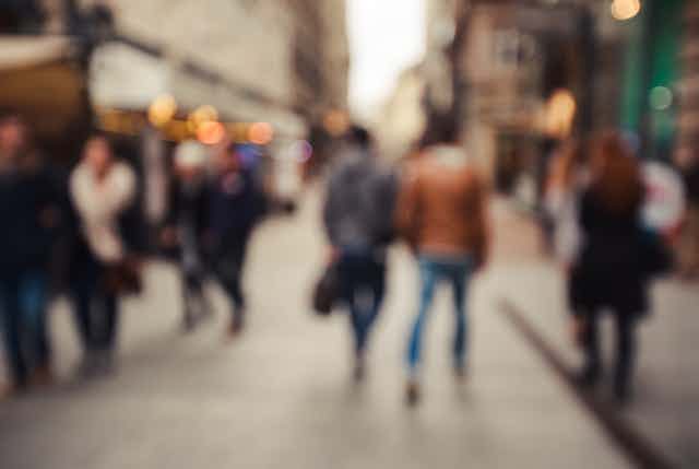 Blurred image of passers-by in a city.