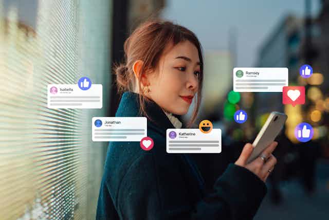 A woman scrolls through social media on her phone.