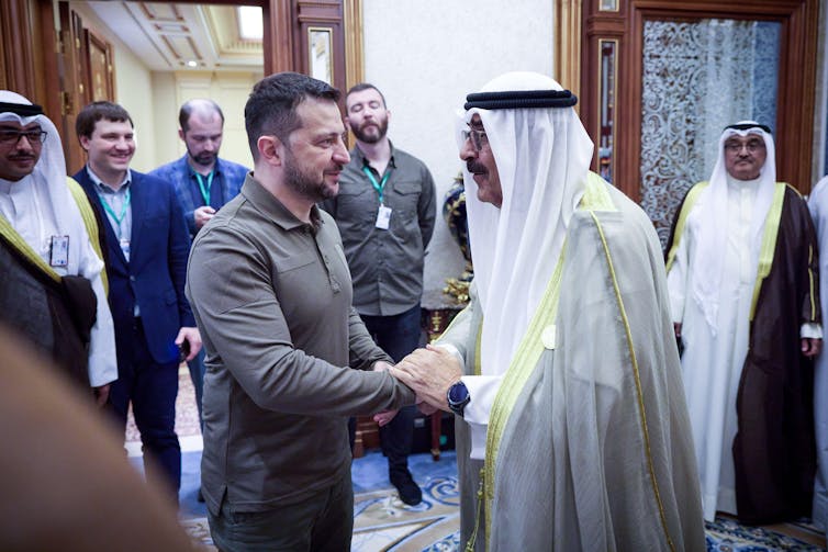 Ukrajinský prezident Volodymyr Zelenskyj si podáva ruku s kuvajtským korunným princom Mishaalom Al-Ahmadom Al-Jaberom Al-Sabah na bilaterálnom stretnutí na okraji summitu Ligy arabských štátov v máji 2023.