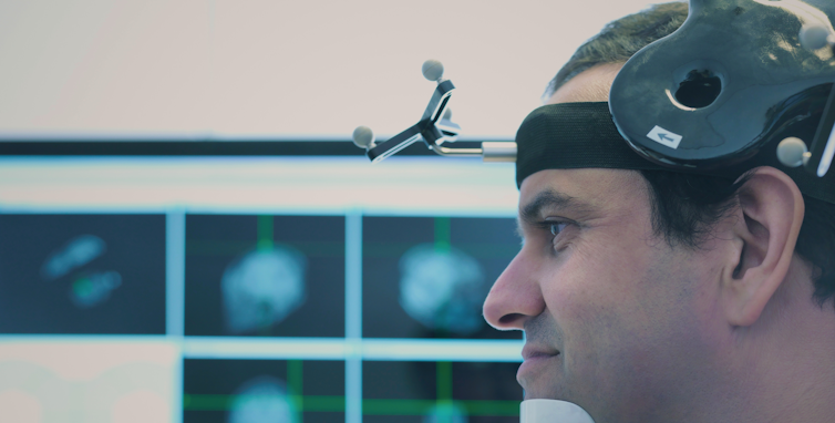 man sits in lab setting with equipment on