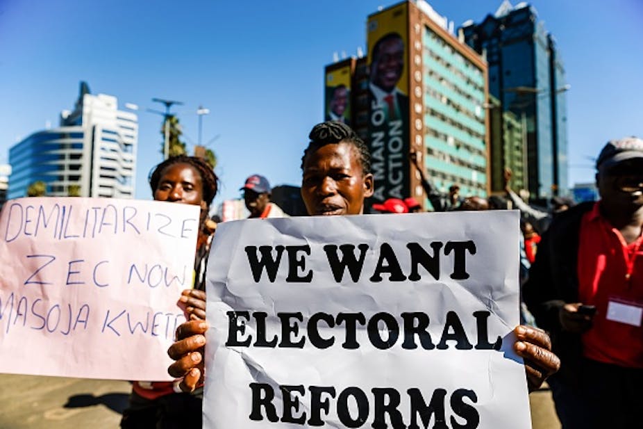 Two women with placards calling for electoral reforms and demilitarisation of Zimbabwe's electoral body.