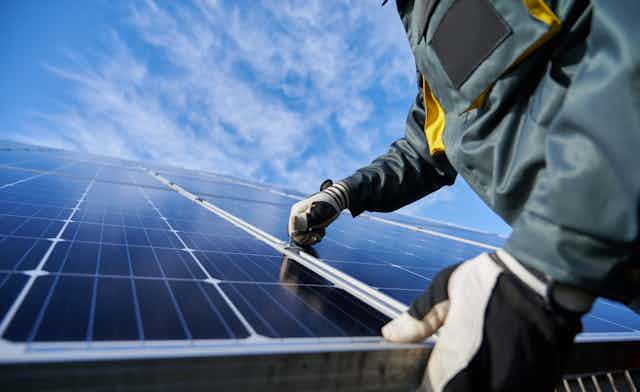 gloved hands stalling solar panels