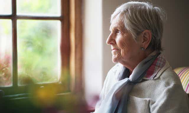 Older woman looks out the window