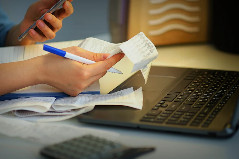 Woman check receipts and looks at a calculator