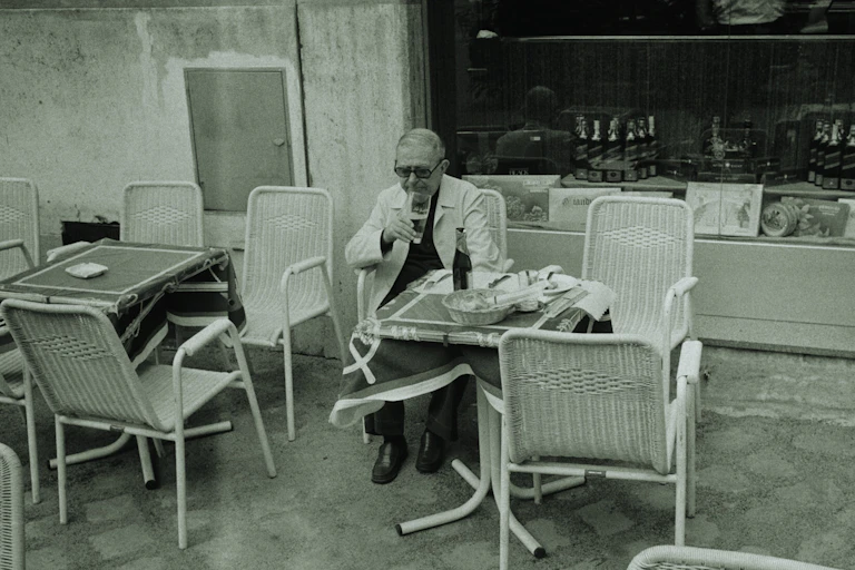 Man sits drinking at outdoor cafe table