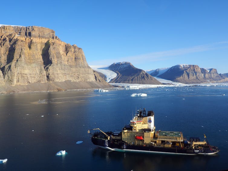 Ship in front of huge cliffs
