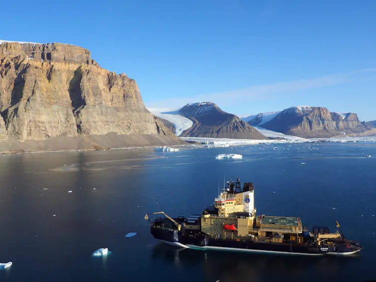 Ship in front of huge cliffs