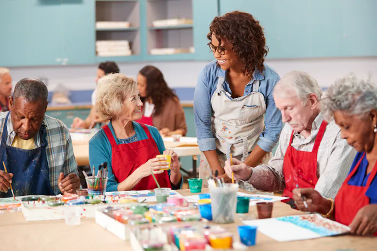 Un groupe de personnes âgées dans un cours d’arts plastiques avec leur enseignante