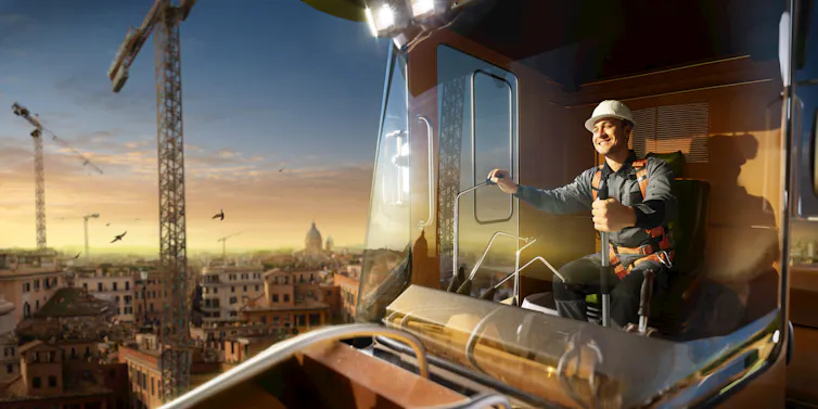 Man inside crane cabin smiling