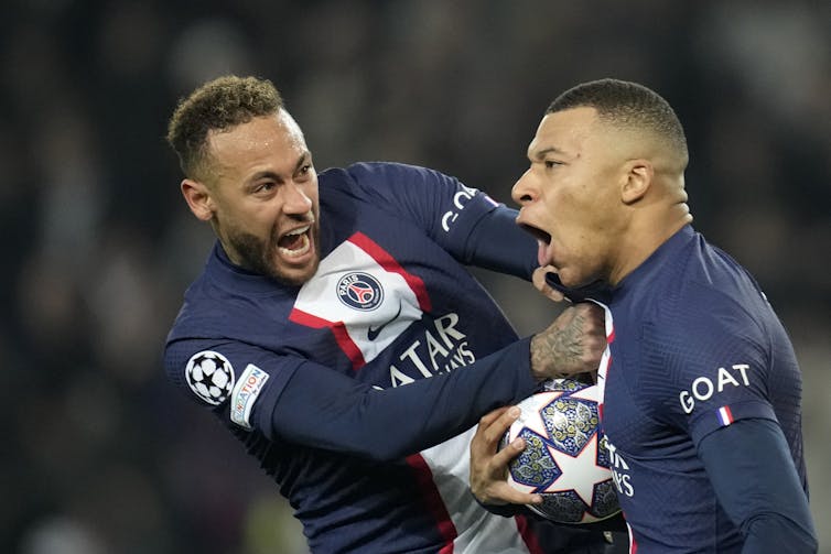 Neymar and Mbappé celebrate together on a football pitch.