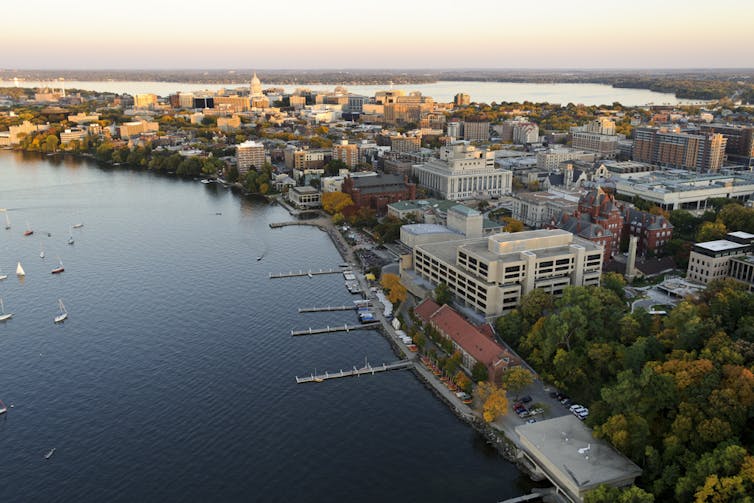 An aerial photo shows the shoreline of Lake Mendota and the University of Wisconsin-Madison campus.