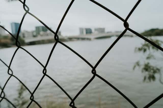View of city and river through chainlink fence