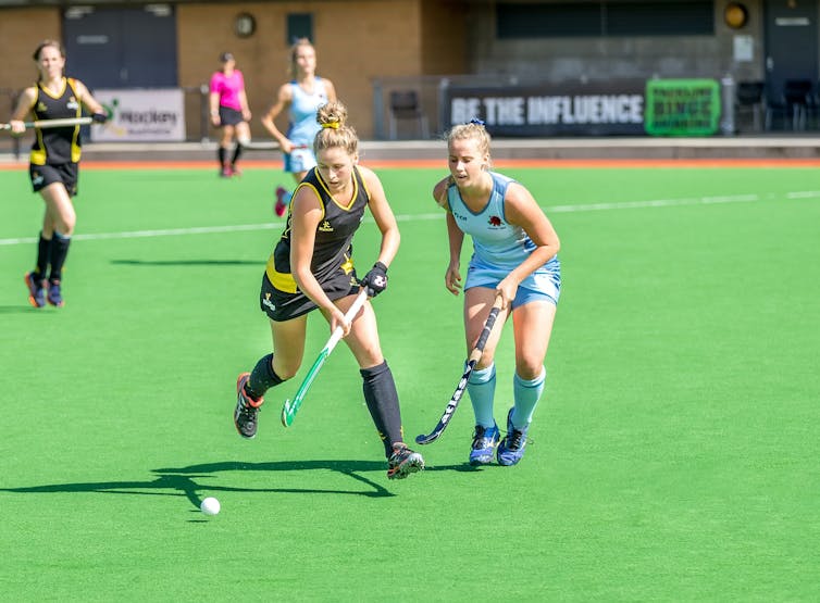Women playing hockey.