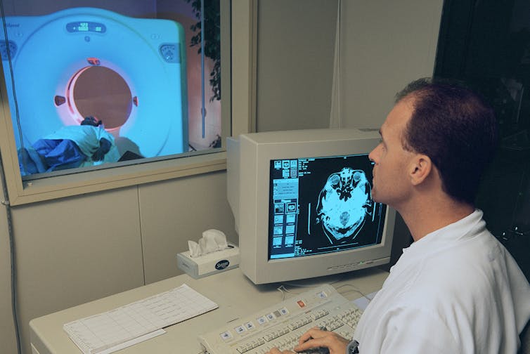 technician conducts MRI scan