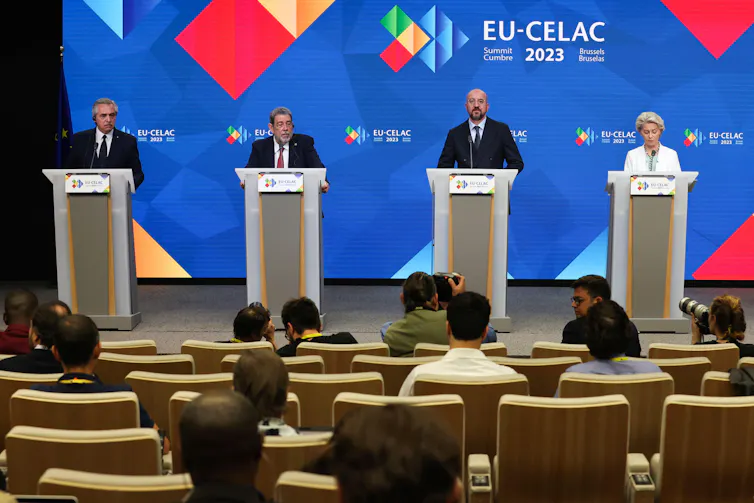Leaders stand at podiums on a stage.