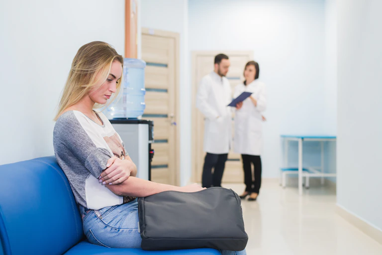 Joven esperando nerviosa a los médicos