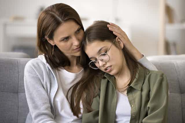 Mother comforting teen daughter