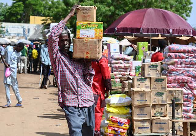Un homme transporte des caisses de nourriture au marché principal de Niamey, le 8 août 2023.