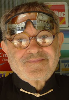 Retrato en primer plano de un hombre que lleva gafas y, encima de ellas, otras gafas de sol.