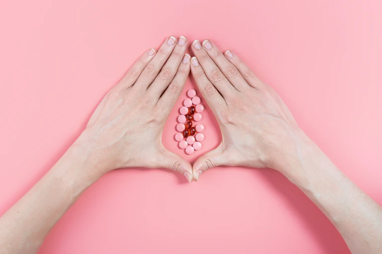 abstract image of female genital organs from hands and pills.