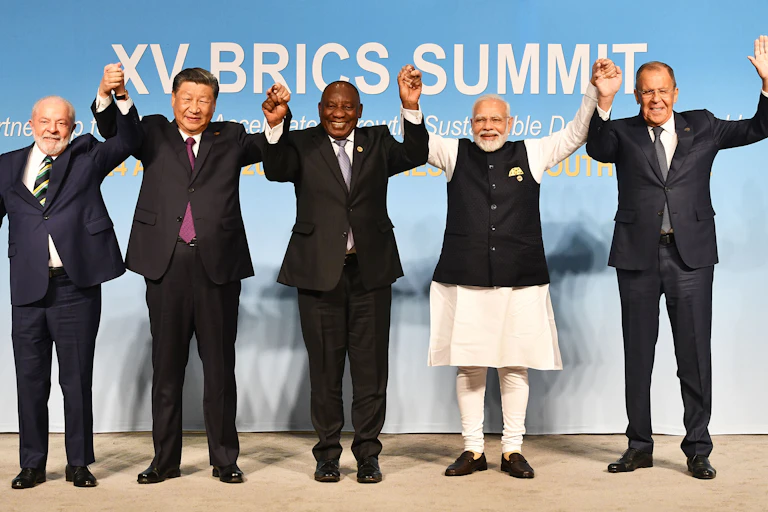 Five men lift locked hands high.