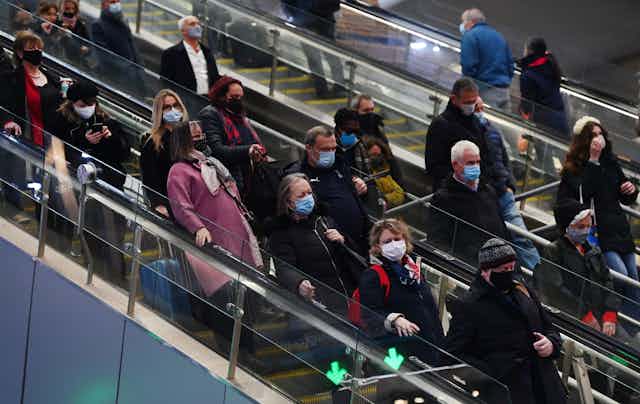 People on an escalator wearing masks