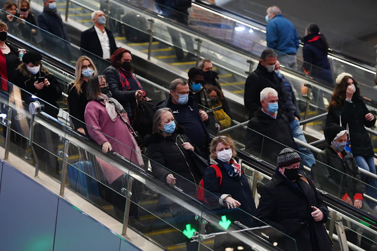 People on an escalator wearing masks