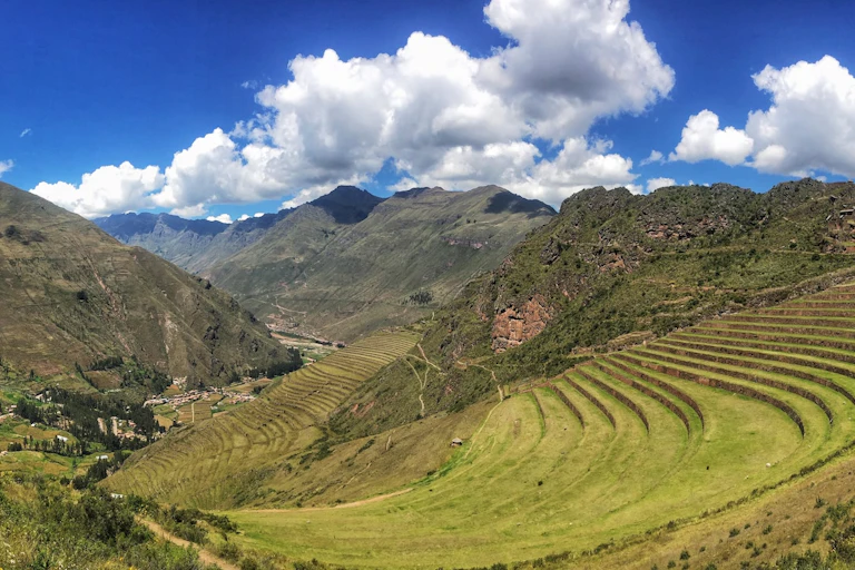 Paisaje peruano de montañas con escaleras de hierba y grandes montañas al final.