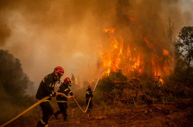 Des pompiers luttent contre un incendie sur l'île grecque d'Evia, le 9 août 2021.