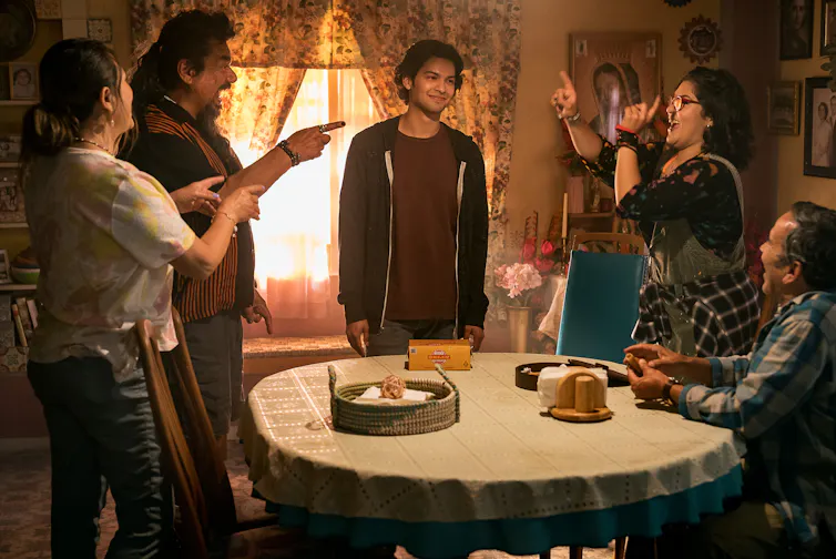 Jamie and members of his family talk animatedly around the kitchen table.