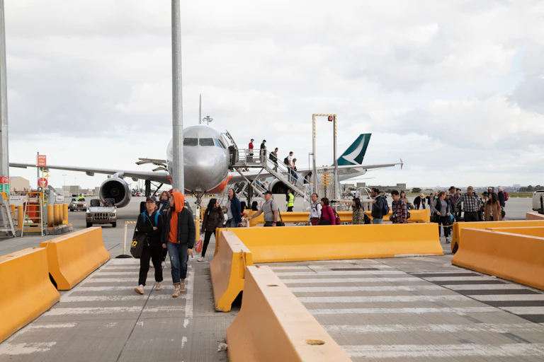 Passengers disembarking from a plane at the airport