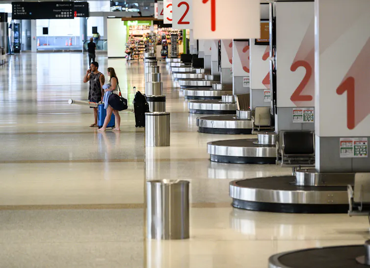 Near-deserted baggage pick-up area at airport during COVID