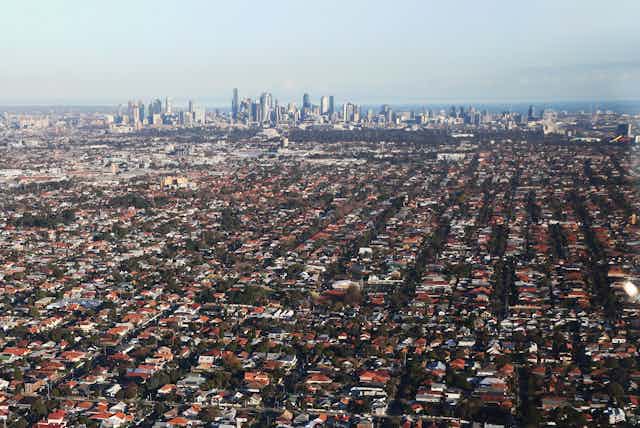 Aerial view of sprawling suburbs looking across to CBD on horizon