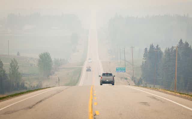 Perspective shot of a two-lane highway disappearing into a smoky landscape