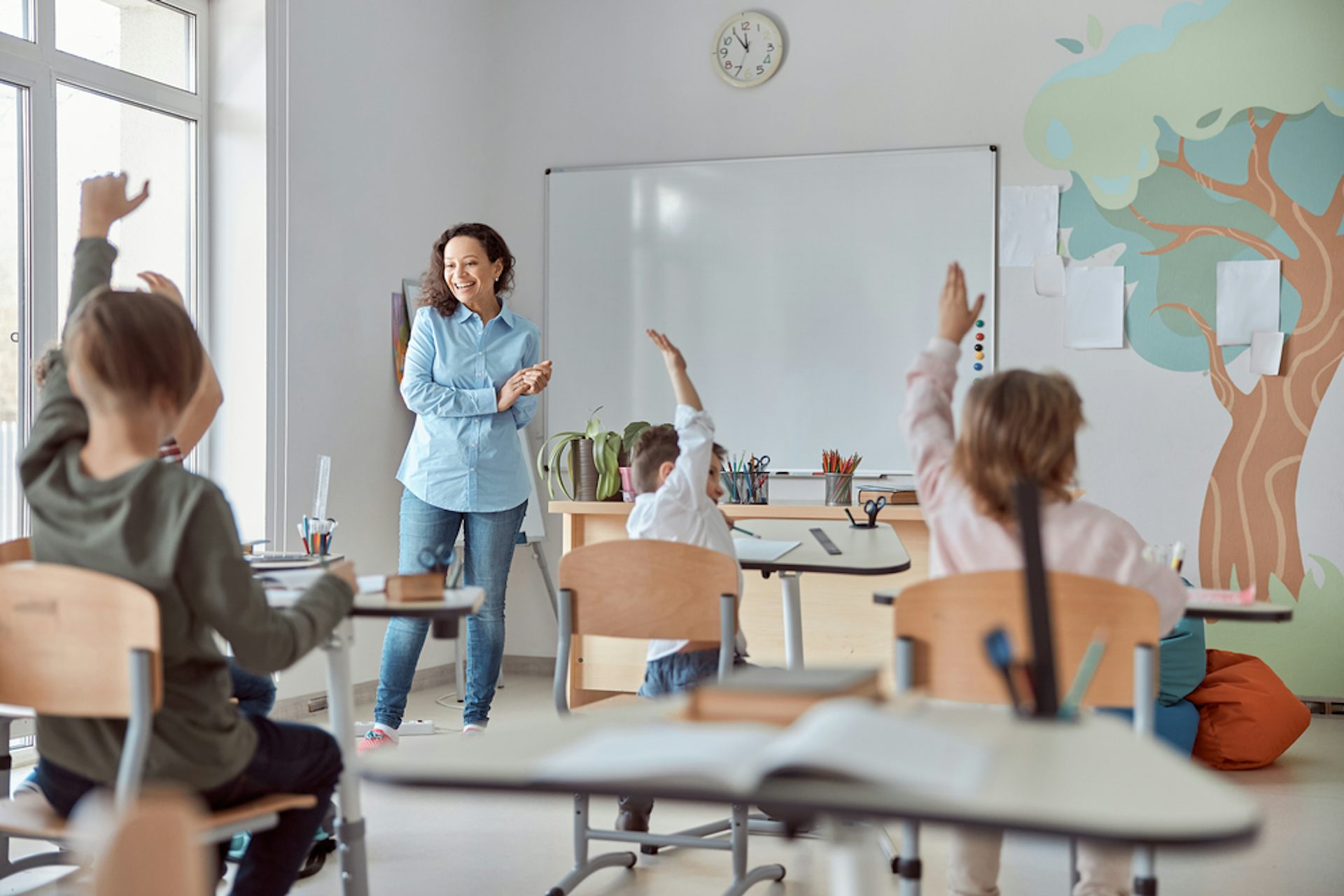 Des élèves de primaire répondent aux questions de leur professeur dans une salle de classe moderne