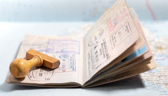 An open passport with a stamp applicator lying on top of it
