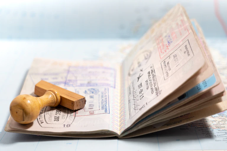An open passport with a stamp applicator lying on top of it