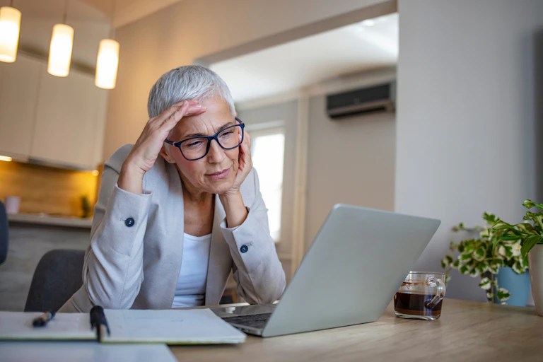 A woman on her laptop with blue glasess.