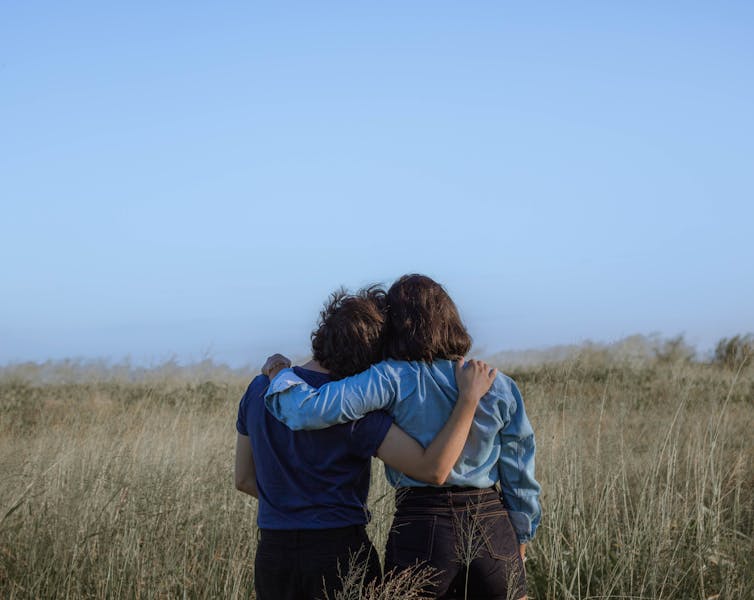 Two women hugging in nature.
