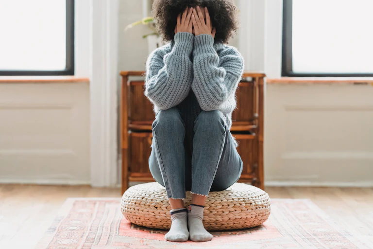 Woman sitting with head in hands.