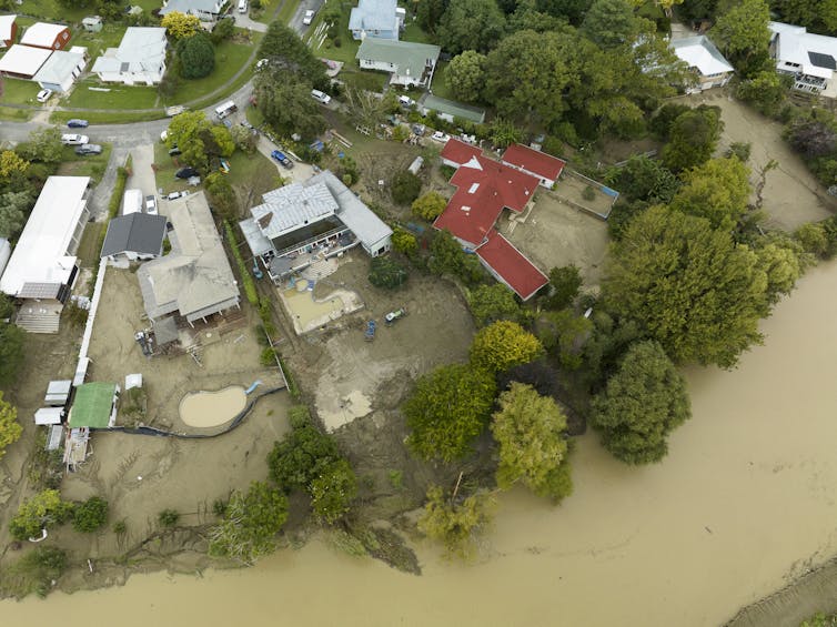 An aerial view of houses inundated bt floodwaters and silt.