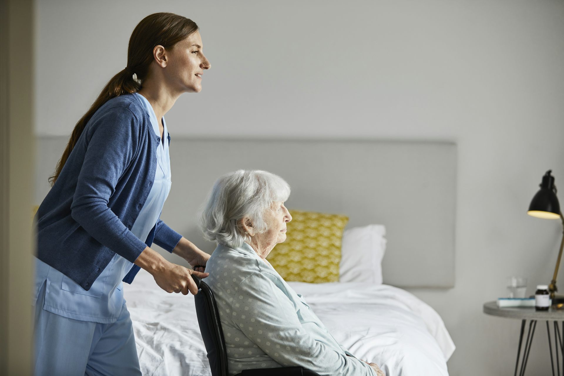 Aged care worker pushes an elderly resident