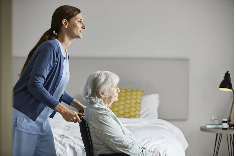 Aged care worker pushes an elderly resident