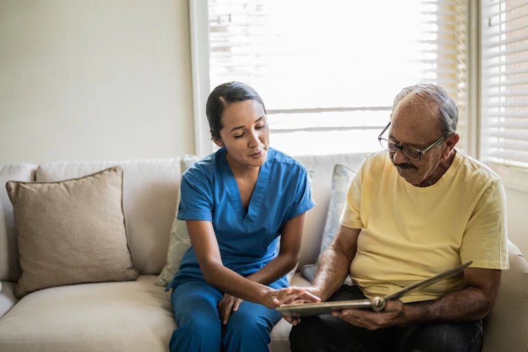 Aged care worker looks at the photo album of an aged resident