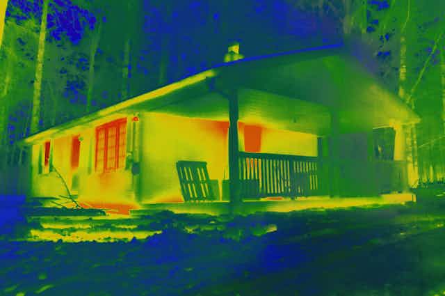 Infrared camera image of home showing heat leaking from windows and doors