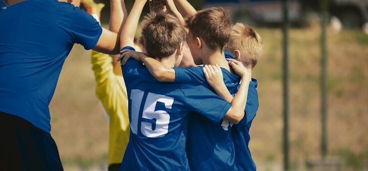 young players huddle on sporting field